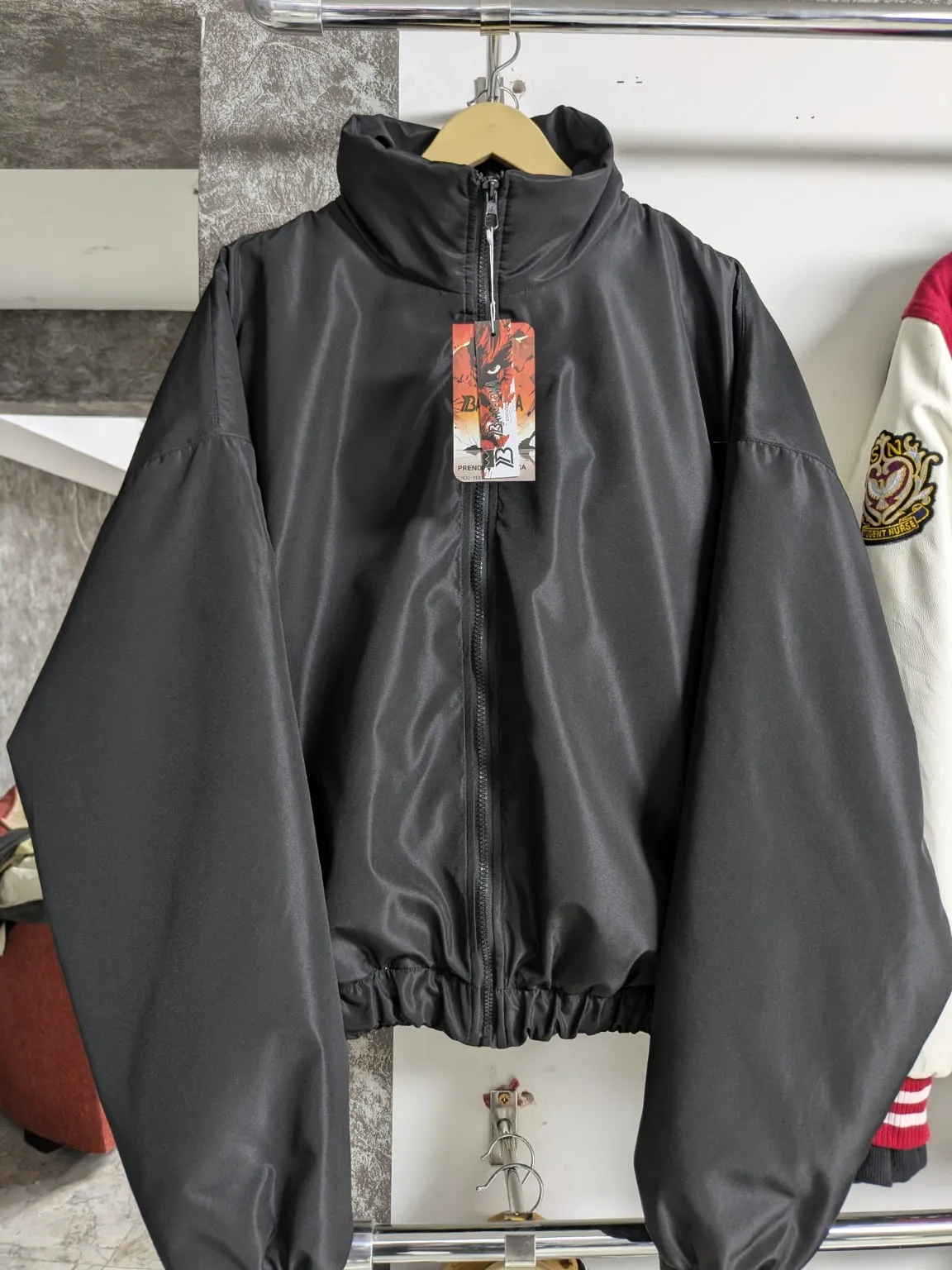 Casaca gris oscuro con cierre, cuello alto y puños y cintura elásticos